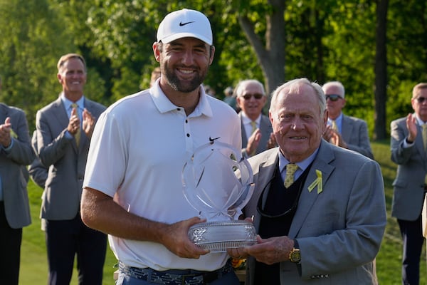 Scottie Scheffler, left, and Jack Nicklaus, right, pose with the trophy after Scheffler won the Memorial golf tournament Sunday, June 1, 2025, in Dublin, Ohio. (AP Photo/Sue Ogrocki)