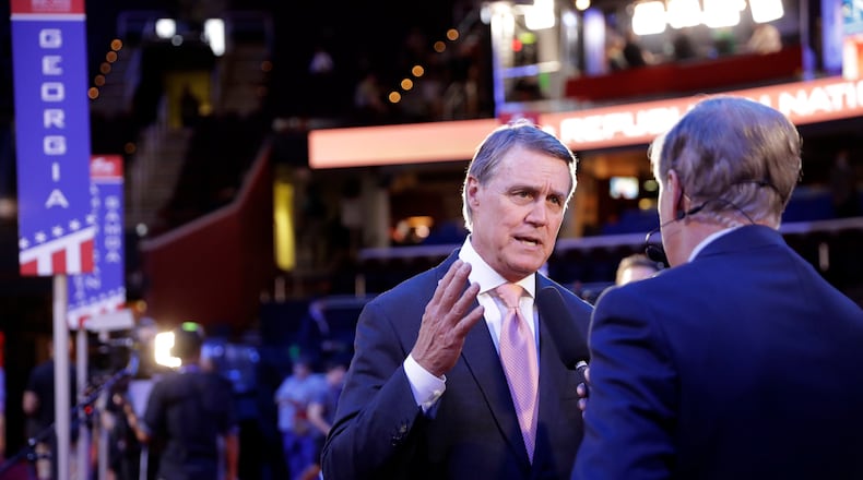 Sen. David Perdue talks to a reporter as he walks around the floor of Quicken Loans Arena during preparation for the Republican National Convention, Sunday in Cleveland. (AP Photo / Matt Rourke)
