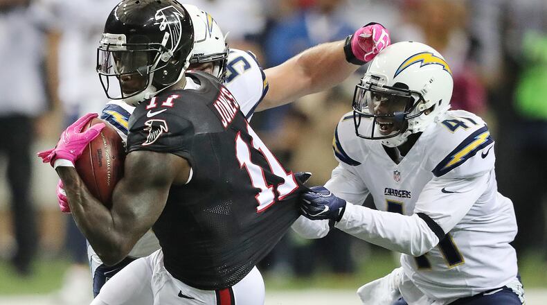 Falcons wide receiver Julio Jones catches a pass against Chargers Steve Williams who holds on to his jersey during the first half in an NFL football game on Sunday, Oct. 23, 2016, in Atlanta. Curtis Compton /ccompton@ajc.com