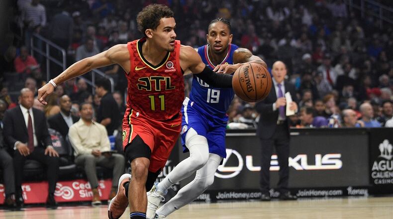 Atlanta Hawks guard Trae Young, left, receives an inbound pass while Los Angeles Clippers guard Rodney McGruder defends during the first half of an NBA basketball game in Los Angeles, Saturday, Nov. 16, 2019. (AP Photo/Kelvin Kuo)