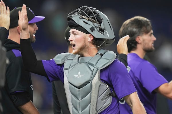 Colorado Rockies catcher Hunter Goodman high-fives with his teammates after the Rockies defeated the Miami Marlins in a baseball game, Tuesday, June 3, 2025, in Miami. (AP Photo/Lynne Sladky)
