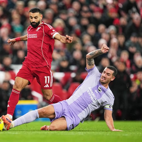 Liverpool's Mohamed Salah, left, challenges for the ball with Brighton's Lewis Dunk during the English Premier League soccer match between Liverpool and Brighton and Hove Albion in Liverpool, England, Saturday, Dec. 13, 2025. (AP Photo/Jon Super)