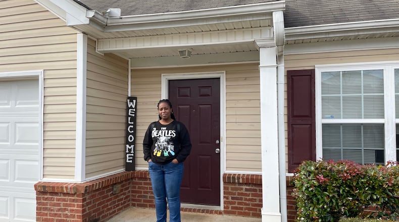Divonia Boyd outside the townhome in Lawrenceville where she now lives with her five children. The family had been staying in an extended stay motel until they were helped by a program called Motel to Home. Photo by Bill Torpy