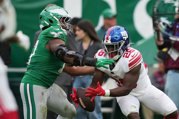 New York Giants running back Devin Singletary (26) makes a first down catch against Philadelphia Eagles linebacker Nakobe Dean (17) during the second half of an NFL football game Sunday, Oct. 26, 2025, in Philadelphia. (Matt Slocum/AP)