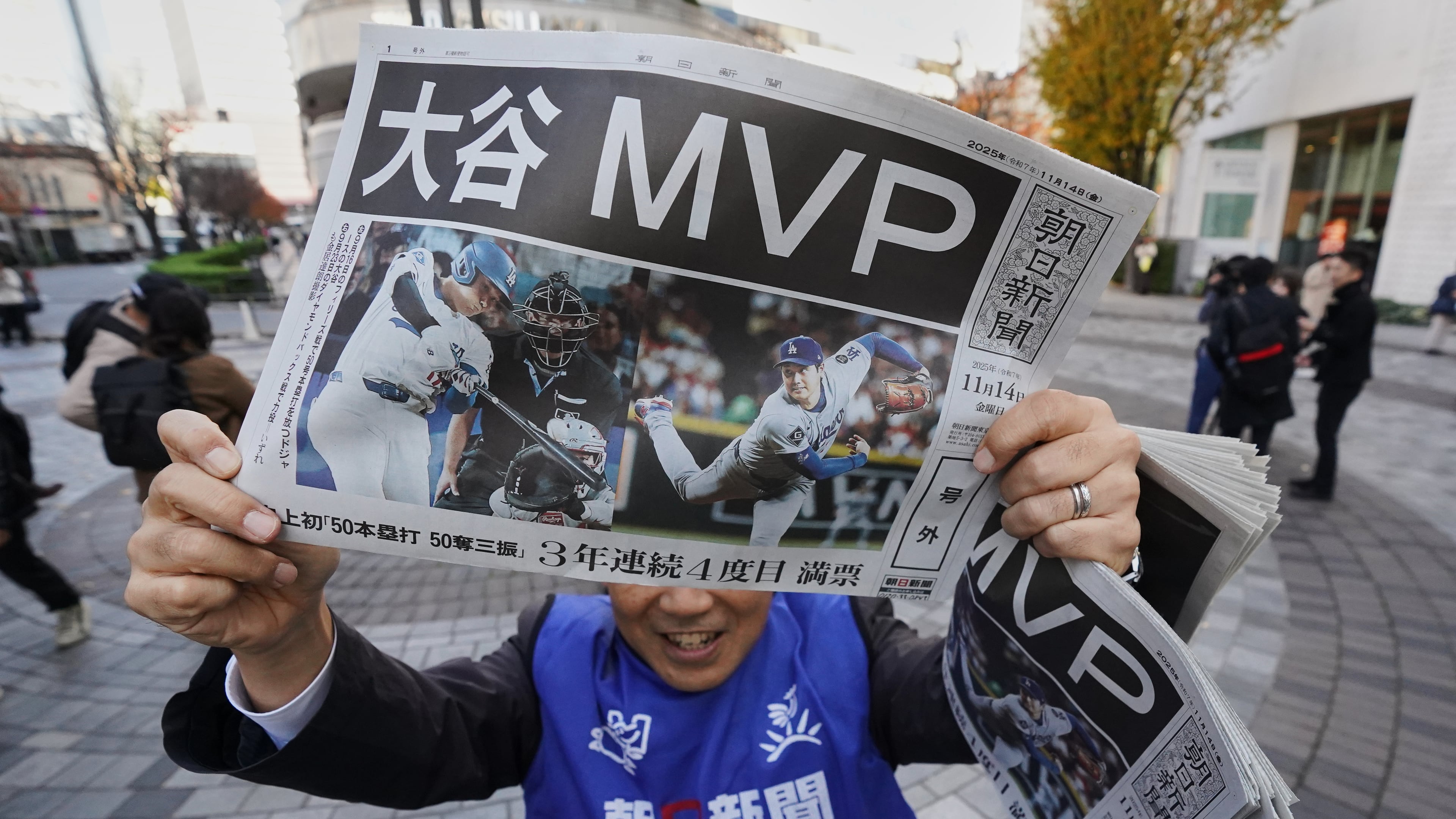 Staff of Japan's newspaper The Asahi Shimbun holds aloft a copy of the extra issue published after the Los Angeles Dodgers Shohei Ohtani won a Most Valuable Player award, in Tokyo, Friday, Nov. 14, 2025. (AP Photo/Koji Ueda)