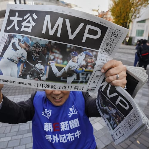 Staff of Japan's newspaper The Asahi Shimbun holds aloft a copy of the extra issue published after the Los Angeles Dodgers Shohei Ohtani won a Most Valuable Player award, in Tokyo, Friday, Nov. 14, 2025. (AP Photo/Koji Ueda)
