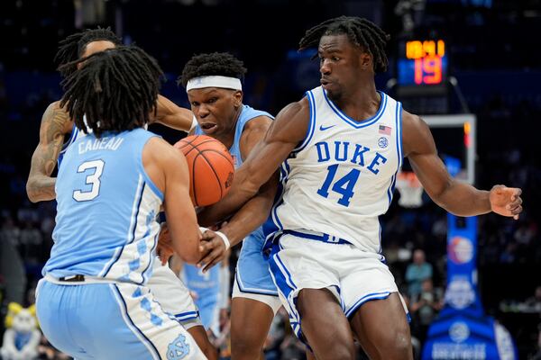 North Carolina guard Elliot Cadeau, from left, forward Ven-Allen Lubin and Duke guard Sion James battle for a loose ball during the first half of an NCAA college basketball game in the semifinals of the Atlantic Coast Conference tournament, Friday, March 14, 2025, in Charlotte, N.C. (AP Photo/Chris Carlson)