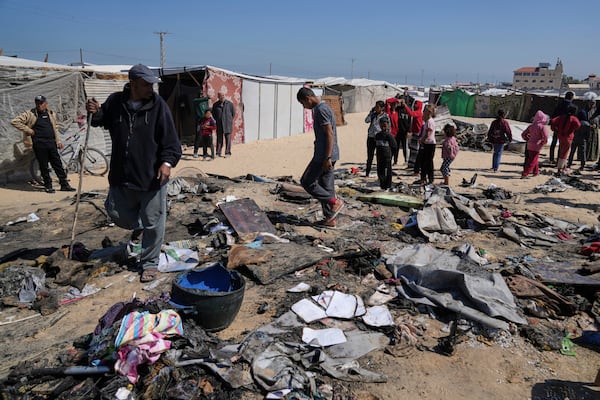 Palestinians inspect the remains of a displacement tent hit by an Israeli airstrike overnight, killing 10 members of the Abu Al-Rous family, in Khan Younis, southern Gaza Strip, Thursday, April 17, 2025. (AP Photo/Abdel Kareem Hana)
