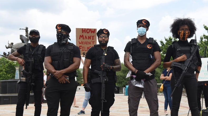 Spiike G. (center) and Whitney Oni (far right) line up with their friends at a protest Wednesday, June 3, 2020, on the Decatur Square. The group dressed as Black Panthers, but they are models and actors. RYON HORNE / AJC