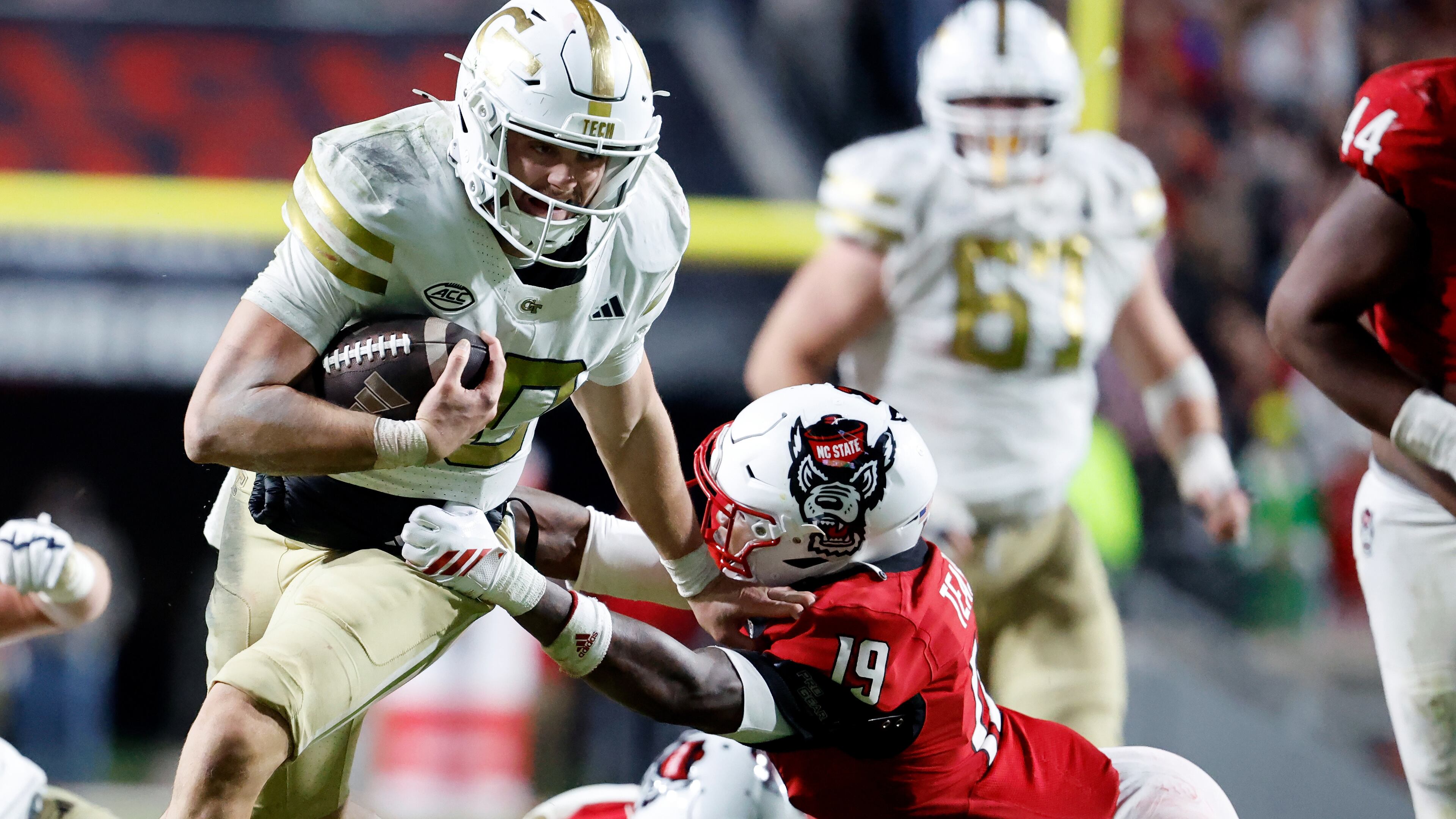 Georgia Tech quarterback Haynes King (10) tries to break away from North Carolina State safety Tristan Teasdell (19) during the second half of an NCAA college football game in Raleigh, N.C., Saturday, Nov. 1, 2025. (AP Photo/Karl DeBlaker)