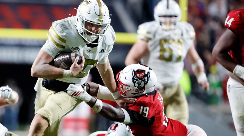 Georgia Tech quarterback Haynes King (10) tries to break away from North Carolina State safety Tristan Teasdell (19) during the second half of an NCAA college football game in Raleigh, N.C., Saturday, Nov. 1, 2025. (AP Photo/Karl DeBlaker)