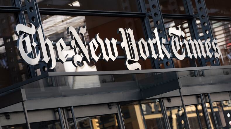 FILE - A sign for The New York Times hangs above the entrance to its building in New York, May 6, 2021. (AP Photo/Mark Lennihan, File)