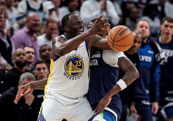 Golden State Warriors forward Draymond Green (23) is defended by Minnesota Timberwolves center/forward Naz Reid (11) and gets a technical foul for contact during the first half of Game 2 of an NBA basketball second-round playoff series Thursday, May 8, 2025, in Minneapolis. (Carlos Avila Gonzalez/San Francisco Chronicle via AP)