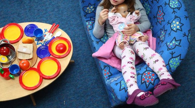 A girl plays with a baby doll at a day care center for children aged 12 months to six years on December 22, 2011 in Munich, Germany.
