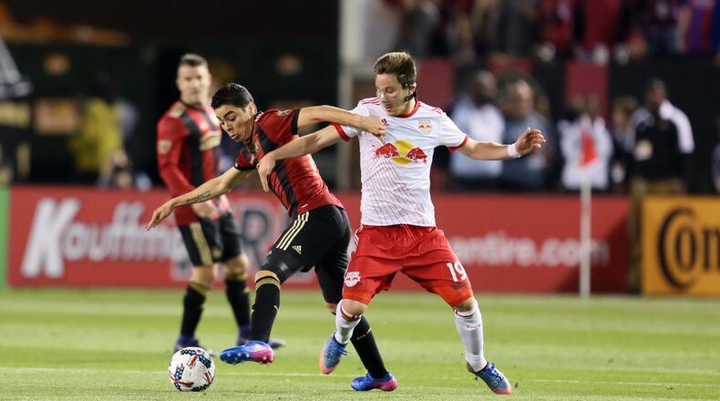 Atlanta United midfielder Miguel Almiron battles for the ball against New York Red Bulls midfielder Alex Muyl during the first half of the inaugural game. (Miguel Martinez / Mundo Hispanico)