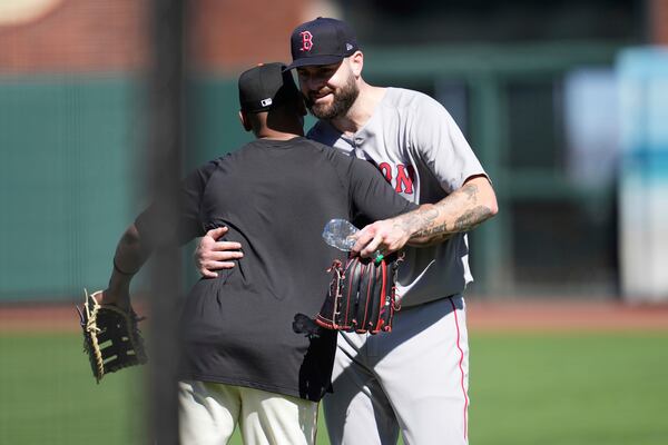 San Francisco Giants' Rafael Devers, left, hugs Boston Red Sox pitcher Lucas Giolito before a baseball game in San Francisco, Friday, June 20, 2025. (AP Photo/Jeff Chiu)