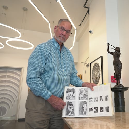 Art dealer Bill DeLind shows a picture of a Pablo Picasso sketch (upper left) stolen from his shop DeLind Fine Art Appraisals in 2018 in Milwaukee on Aug. 14, 2026. The sketch was recently found in town. (AP Photo/Laura Bargfeld)