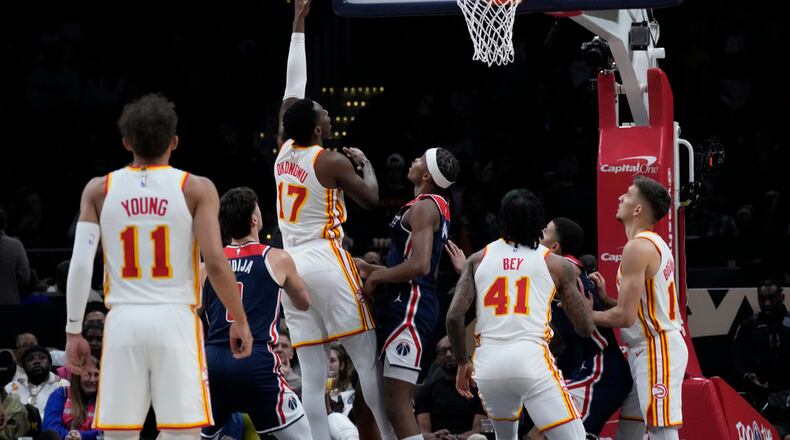 Atlanta Hawks forward Onyeka Okongwu (17) shoots and scores against Washington Wizards guard Bilal Coulibaly, center, during the first half of an NBA basketball game in Washington, Saturday, Nov. 25, 2023. (AP Photo/Manuel Balce Ceneta)