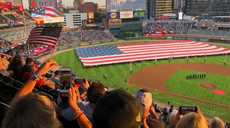 Fans take photos during a pre-game ceremony in remembrance of the 9/11 attacks prior to a game between the Braves and the Miami Marlins on Saturday, Sept. 11, 2021, in Atlanta. (AP Photo/Ben Margot)