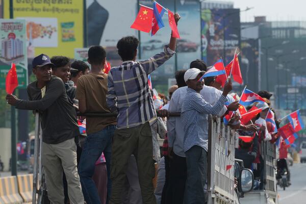 Cambodian villagers stand on the back of trucks as they arrive to welcome Chinese President Xi Jingping's arrival in Phnom Penh, Cambodia, Thursday, April 17, 2025. (AP Photo/Heng Sinith)