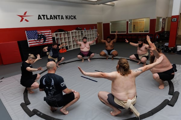 The Black Dragon Beya sumo club squats in a circle together before practice at Atlanta Kick in Atlanta, June 30, 2026. (Estela Muñoz/AJC)