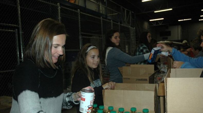 Volunteers pack food boxes to be donated to needy families through CAC.