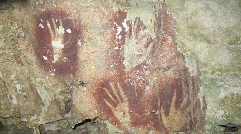 This undated image provided by Maxime Aubert shows handprints with sharpened fingertips in the Maros region of Sulawesi, Indonesia. (Ahdi Agus Oktaviana/Maxime Aubert via AP)