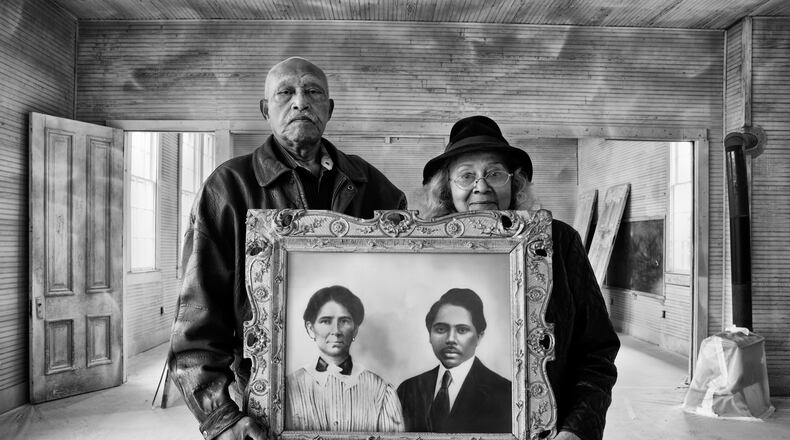 Elroy and Sophia Williams hold a photo of Sophia's grandparents, who were born in slavery but accumulated 1,200 acres of farmland and contributed two acres for a Rosenwald school. They are standing in that structure, the former Hopewell School in Bastrop County, Texas, which Elroy is working to preserve  Photo: Andrew Feiler