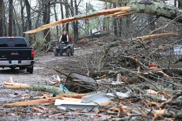 A resident along Tippah County Rd. 122 in the Three Forks Community near Walnut, Miss., makes his way down his driveway Thursday, April 3, 205, to inspect the tornado damage in the daylight hours. (Thomas Wells /The Northeast Mississippi Daily Journal via AP)