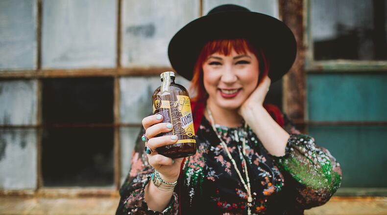 Melanie Wade holds a bottle of Golda Kombucha / Contributed by Golda Kombucha