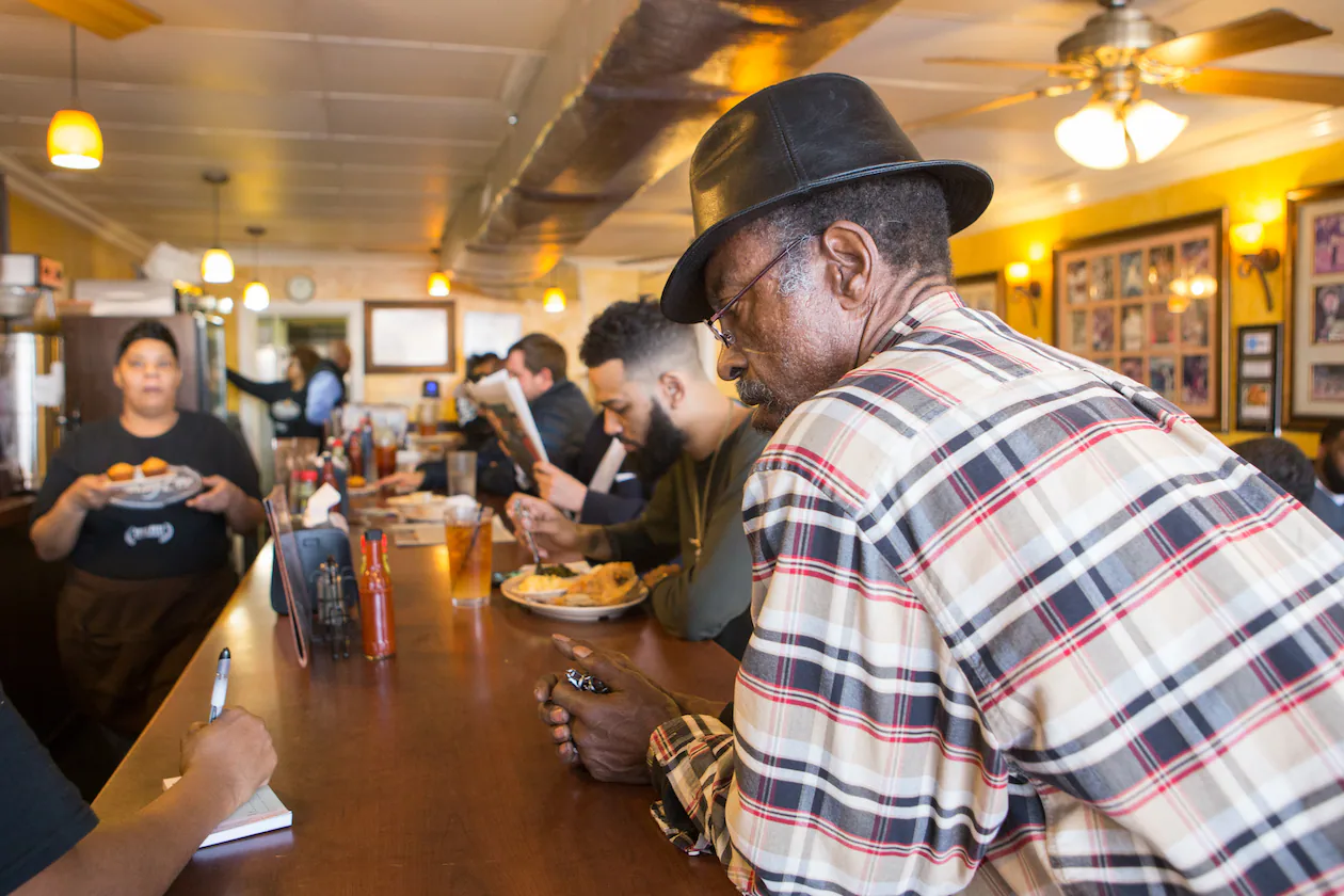 Johnny Scott, a regular at the Busy Bee Cafe, orders oxtails to go at the restaurant on Martin Luther King Jr. Drive in Atlanta in January 2020. The historic soul food restaurant, which opened in 1947, is opening new locations the next two years. (Jenni Girtman for the AJC)