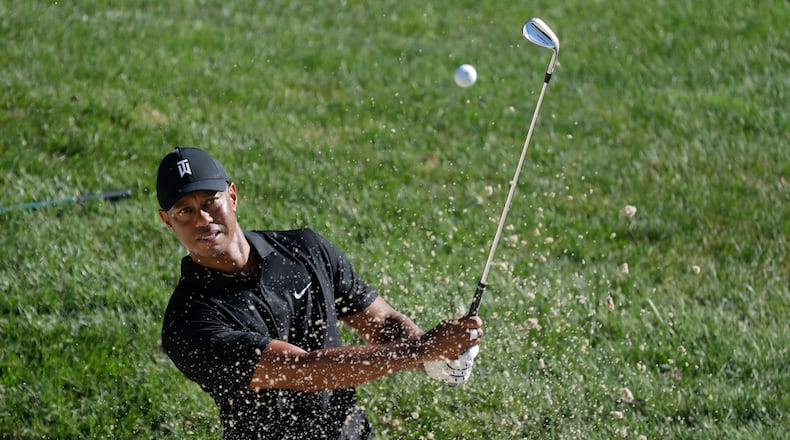 Tiger Woods gets in a little work from out of the bunker during a Tuesday morning practice round for the upcoming Memorial Tournament. (AP Photo/Darron Cummings)