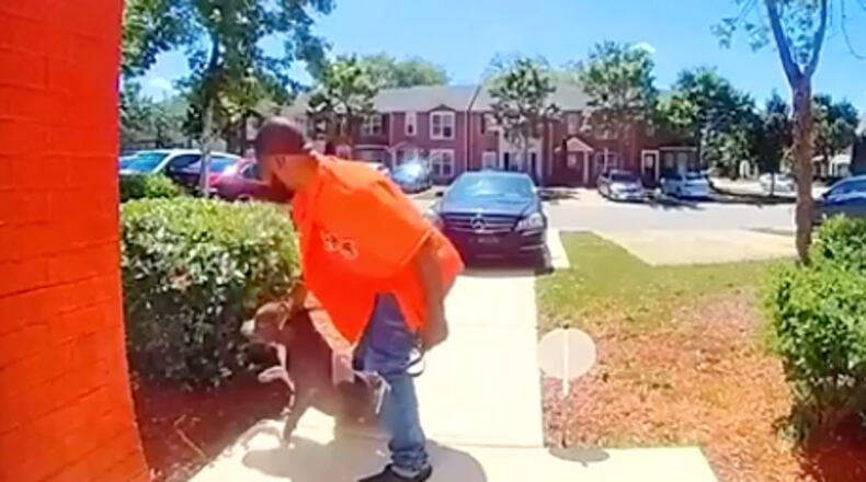 A Clayton County man who was identified by police as Michael Gibbs appears to drag a pit bull after punching it in the head.