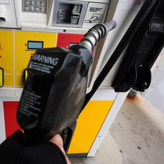 FILE - A gas price is displayed as a customer holds a fuel pump nozzle before filling up her vehicle's gas tank at a gas station, in Lincolnshire, Ill., Wednesday, April 15, 2026. (AP Photo/Nam Y. Huh, file)