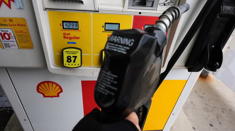 FILE - A gas price is displayed as a customer holds a fuel pump nozzle before filling up her vehicle's gas tank at a gas station, in Lincolnshire, Ill., Wednesday, April 15, 2026. (AP Photo/Nam Y. Huh, file)