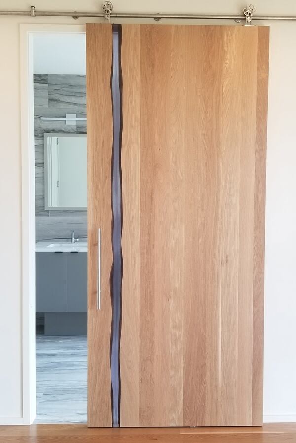 Atlanta-based Two Chair Studio’s custom white oak and smoke resin sliding door adds an artful and unexpected touch. Contributed by twochair.biz