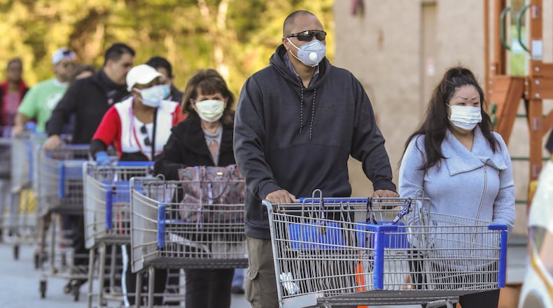 Mask-wearing shoppers lined up over the length of a football field at the Sam’s Club on Clairmont Road in DeKalb County on April 3, 2020. JOHN SPINK/JSPINK@AJC.COM