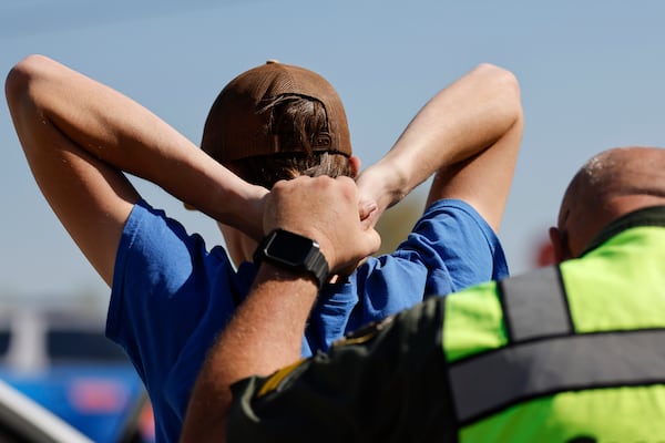 A person is detained at a license check and sobriety checkpoint off an exit on I-16 in Twiggs County, southeast of Macon, on Saturday, March 14, 2026. (Arvin Temkar/AJC)