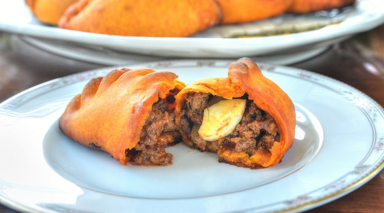 Salteñas, a Bolivian pastry, are filled with meat. This recipe also calls for hard-cooked eggs as well as olives and raisins. STYLING BY LESLY SOBEL / CONTRIBUTED BY CHRIS HUNT PHOTOGRAPHY