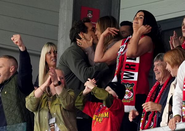 Wrexham co-owner Ryan Reynolds, top left, kisses his wife Blake Lively after Wrexham scored their first goal English League One soccer match between Wrexham and Charlton Athletic at the Racecourse ground in Wrexham, Wales, Saturday, April 26, 2025. (Martin Rickett/PA via AP)