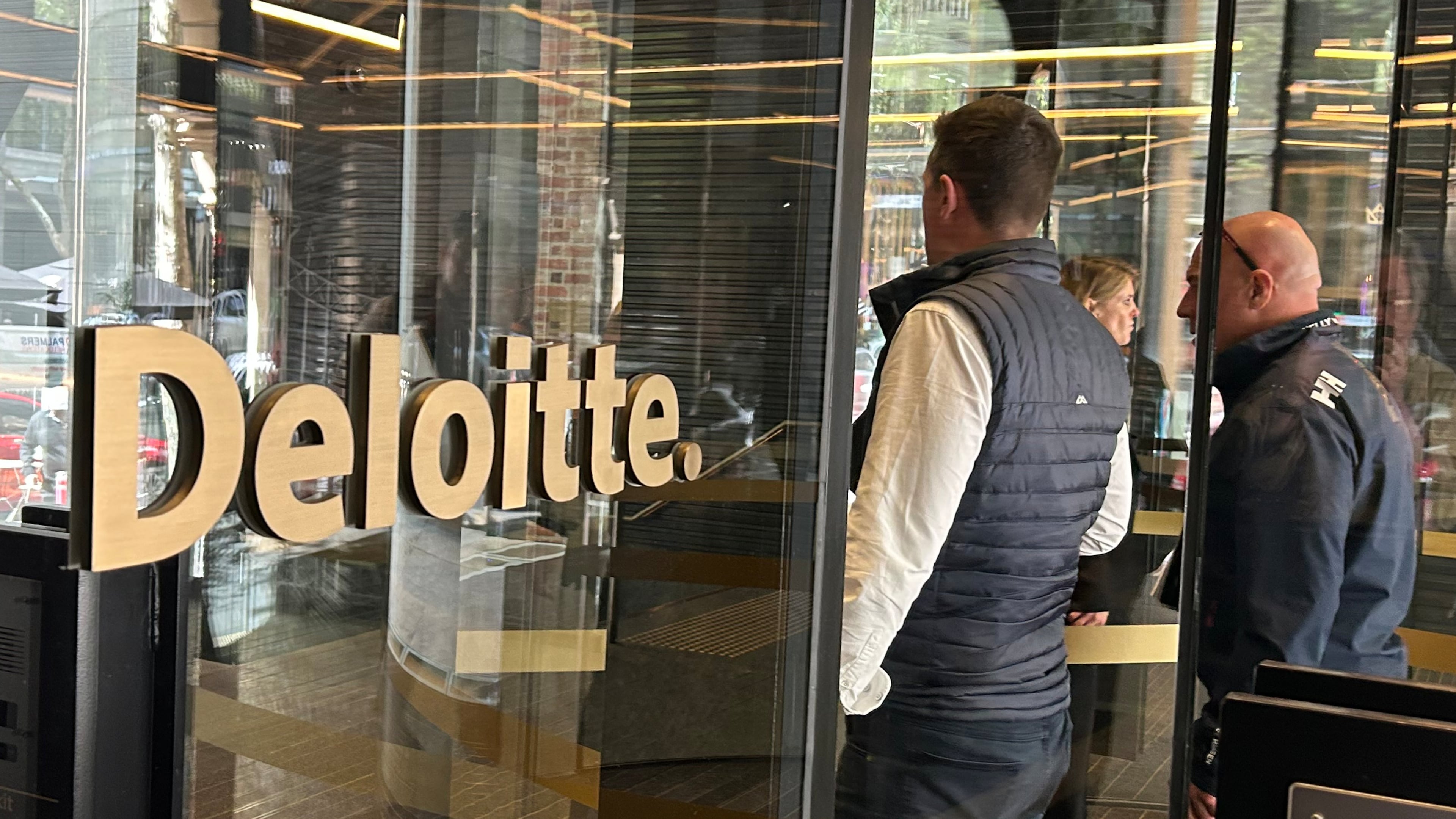 People arrive at the offices of Deloitte in Melbourne, Australia, on Tuesday, Oct. 7, 2025. (AP Photo/Rod McGuirk)