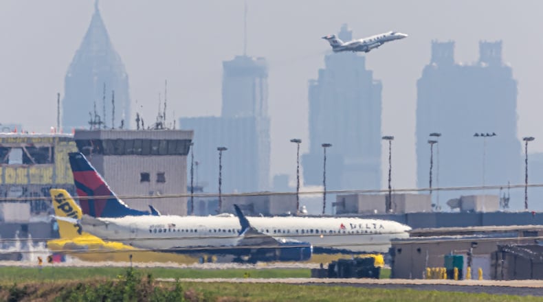 A smoggy skyline rose behind Hartsfield Jackson International Airport on June 12, 2024, when a Code Orange air quality alert was in effect. (John Spink/AJC)