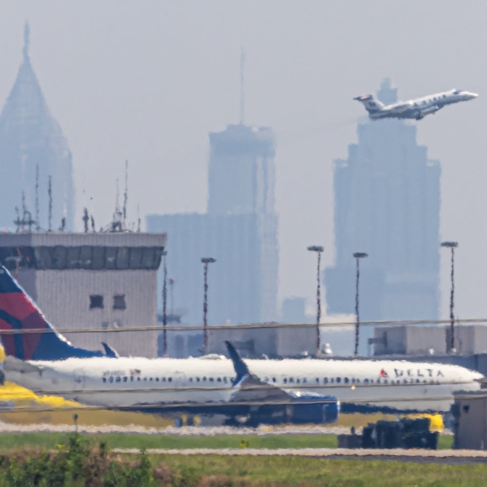 A smoggy skyline rose behind Hartsfield Jackson International Airport on June 12, 2024, when a Code Orange air quality alert was in effect. (John Spink/AJC)