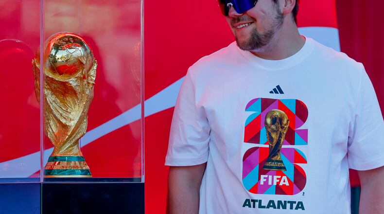Soccer fan Joseph Pozdnakov has his photo taken during the FIFA World Cup Trophy Tour outside Truist Park before the Atlanta Braves host the Chicago Cubs in a baseball game, Thursday, May 14, 2026, in Atlanta. Eight FIFA World Cup soccer matches will be played in Atlanta.(AP Photo/Erik S. Lesser)