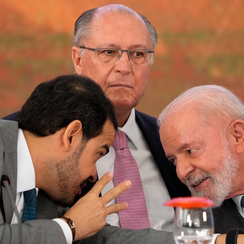 FILE - Brazil's Attorney General Jorge Messias, left, leans over to speak with President Luiz Inacio Lula da Silva at a signing ceremony of a compensation agreement for damages caused by the 2015 collapse of the Mariana Dam owned by the mining company Samarco, a joint venture of Vale and BHP, at the Planalto Presidential Palace, in Brasilia, Brazil, Oct. 25, 2024. Pictured center is Vice President Geraldo Alckmin. (AP Photo/Eraldo Peres)