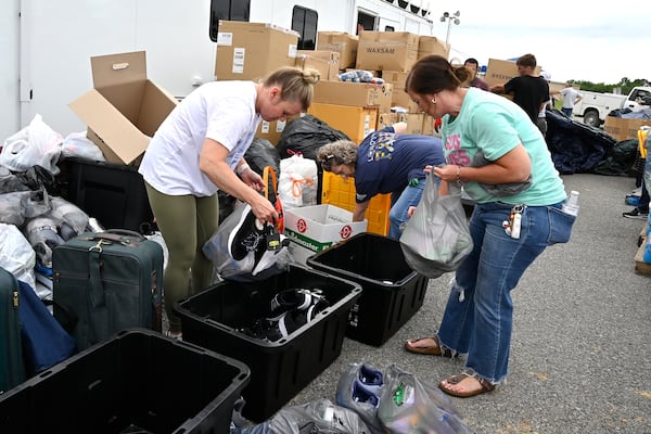 Volunteers sort clothing into bins for distribution at the command center set up at the London-Corbin Airport in London, Ky., Monday, May 19, 2025. (AP Photo/Timothy D. Easley)