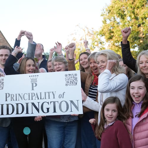 Local residents pose with a "Principality of Piddington" sign in the village of Piddington, Oxfordshire, England, Wednesday, Sept. 16, 2026, after they voted overwhelmingly to become an independent state in a symbolic "referendum". (Joe Giddens/PA via AP)