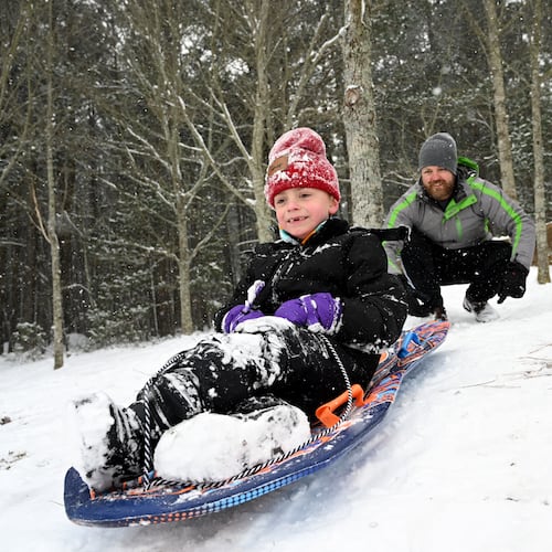 James Myers, 7, sleds down a hill as his father Lee Myers pushes him at Little Mulberry Park in Dacula on Saturday, Jan. 31, 2026. Snow has been steadily falling in North Georgia and has made its way into metro Atlanta. Channel 2 Action News chief meteorologist Brad Nitz said 3 and 4 inches of snow had fallen in Flowery Branch and Buford by 1 p.m. In the northeast corner of Georgia in Rabun County, more than 7 had fallen. (Hyosub Shin/AJC)