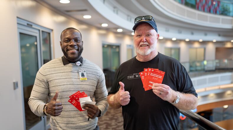 Kevin Campbell (right) brought gift cards for Clear manager Byran McCray to give to struggling TSA workers Friday (Ben Hendren for the AJC)