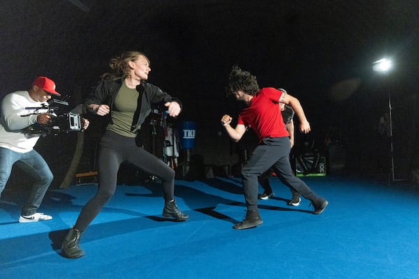 Stunt actors Jess Durham, second from left, and Brandon Martinez (in red) are filmed by director of photography Corey Lincoln, left, as they rehearse a fight scene at the Diamond Action Design Studio. (Jason Getz/AJC)